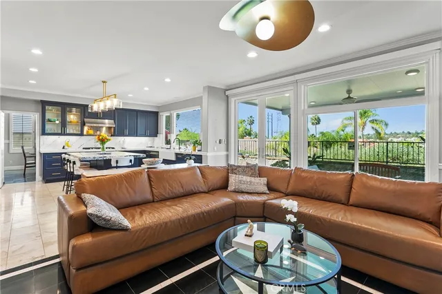 a living room with furniture kitchen and a large window