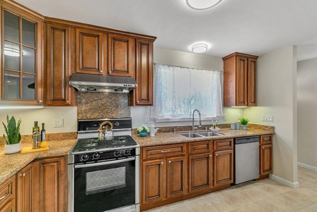 a kitchen with stainless steel appliances granite countertop a stove a sink and a microwave