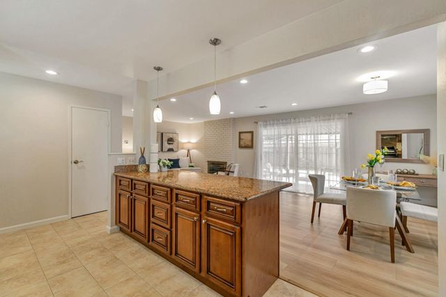 a large kitchen with kitchen island a sink table and chairs
