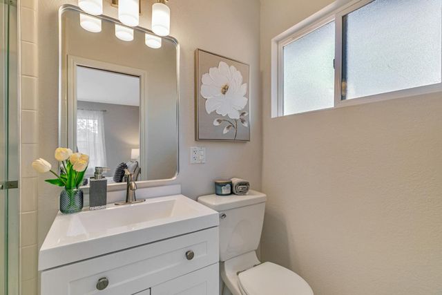 a bathroom with a toilet a sink and mirror