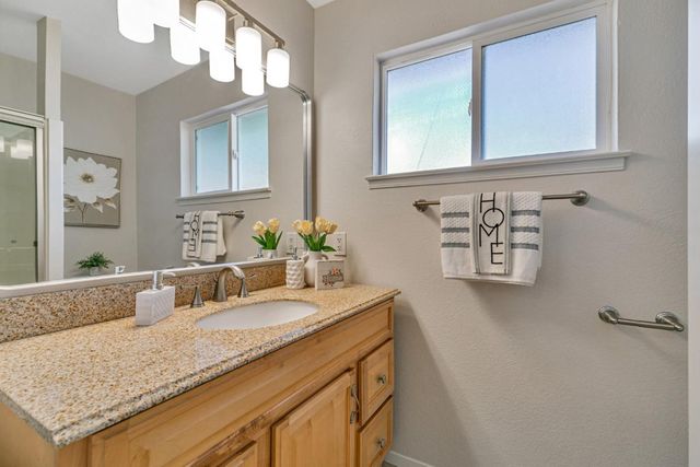 a bathroom with a granite countertop sink and a mirror