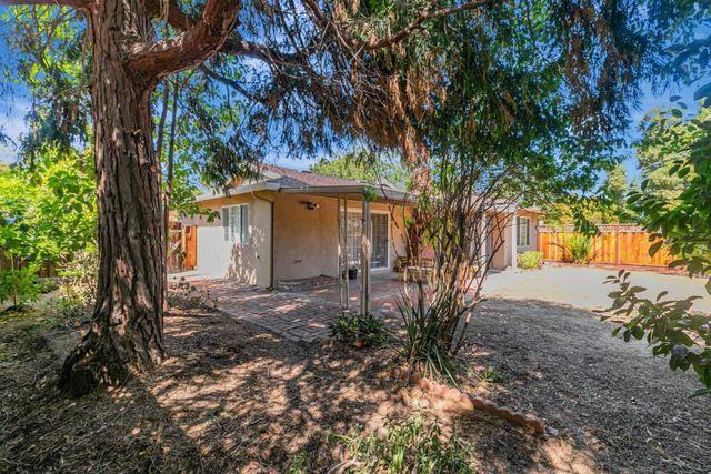 a view of a house with a tree in the yard