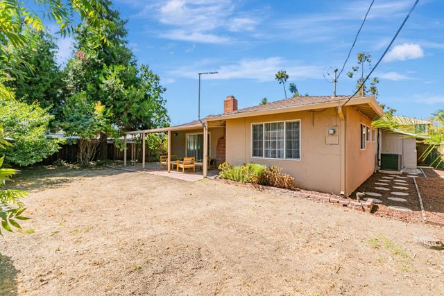 a view of a house with backyard and sitting area