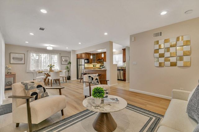 a living room with furniture kitchen view and a table
