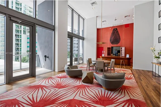 a living room with furniture a large window and a chandelier
