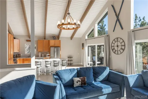 a living room with furniture a large window and a chandelier