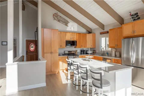 a view of a kitchen with kitchen island granite countertop a large window and a counter top space