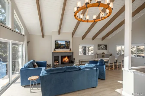 a living room with furniture a fireplace and a large window