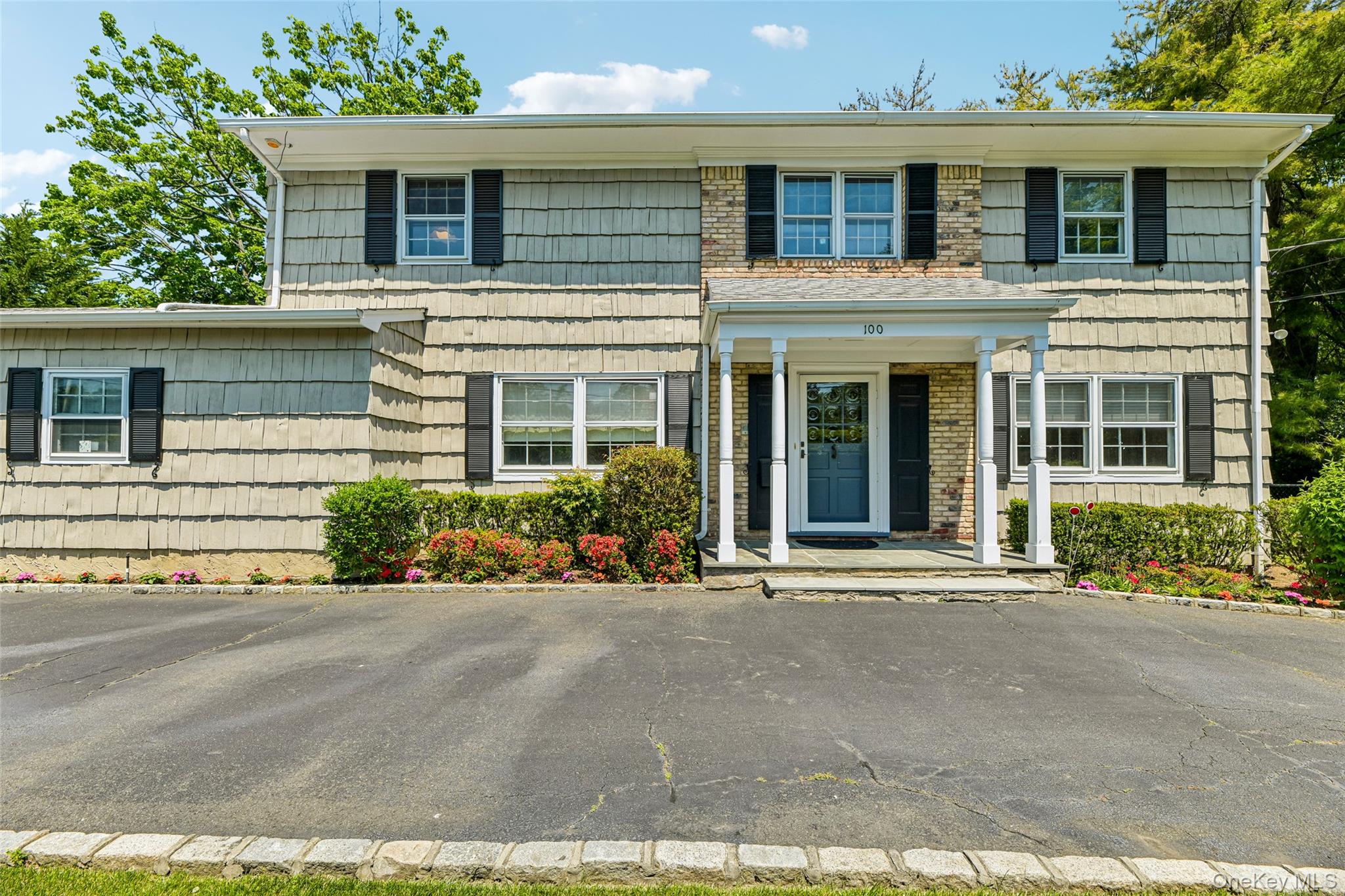100 Hewlett Neck Road Woodmere, NY 11598 - Photo 2 of 45 a front view of a house with a garden