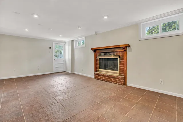 a view of an empty room with a fireplace and a window