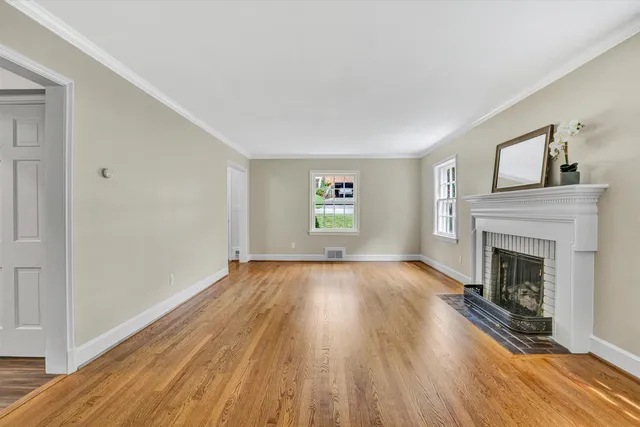 a view of empty room with wooden floor and fireplace