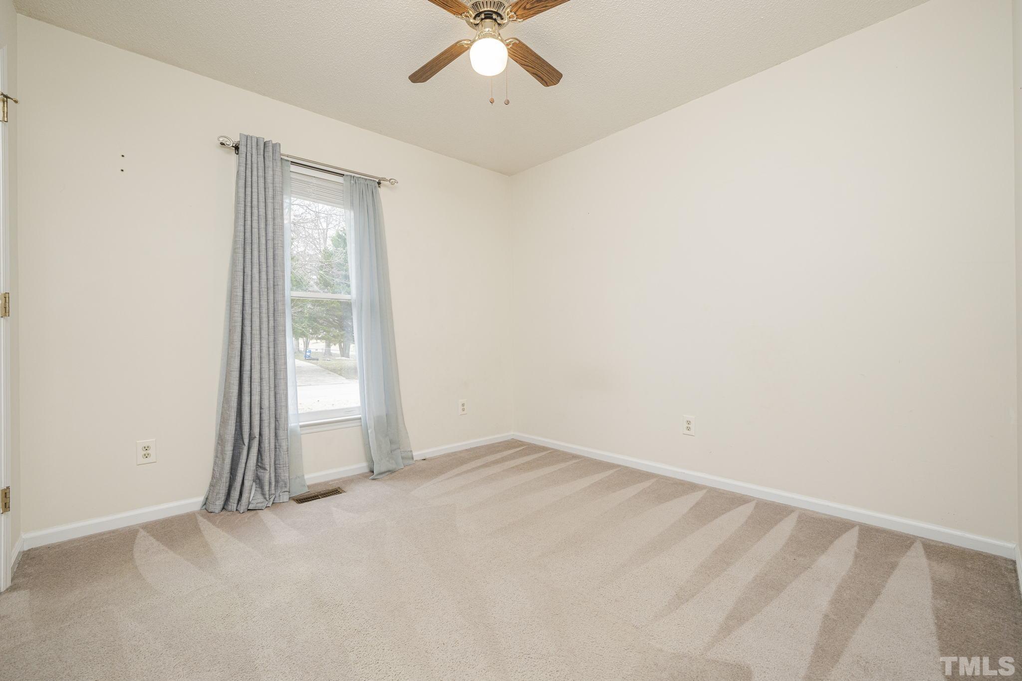 105 Pineview Drive Zebulon, NC 27597 - Photo 19 of 29 an empty room with a empty space and a ceiling fan