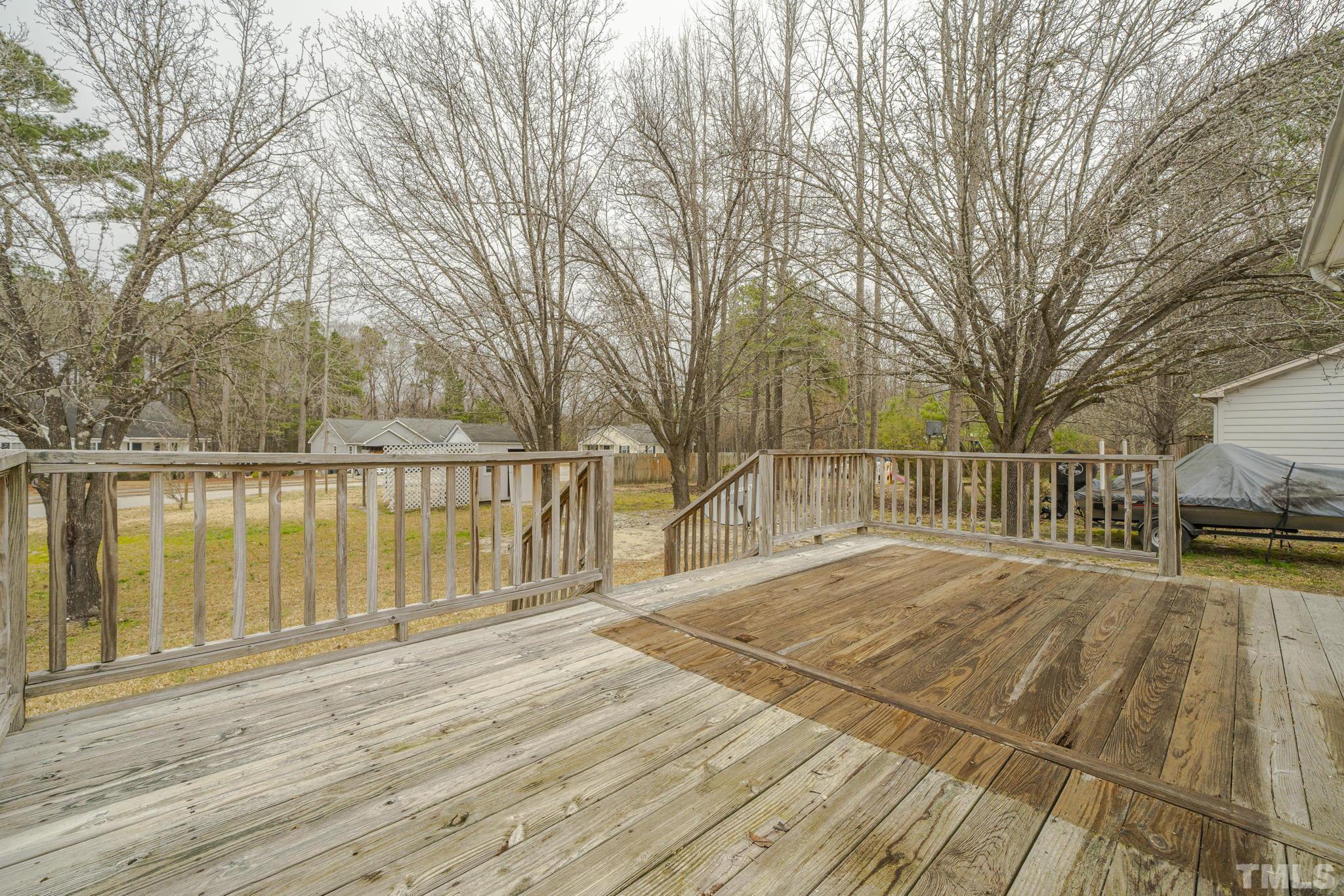 105 Pineview Drive Zebulon, NC 27597 - Photo 23 of 29 a view of wooden deck and lake with trees in the background