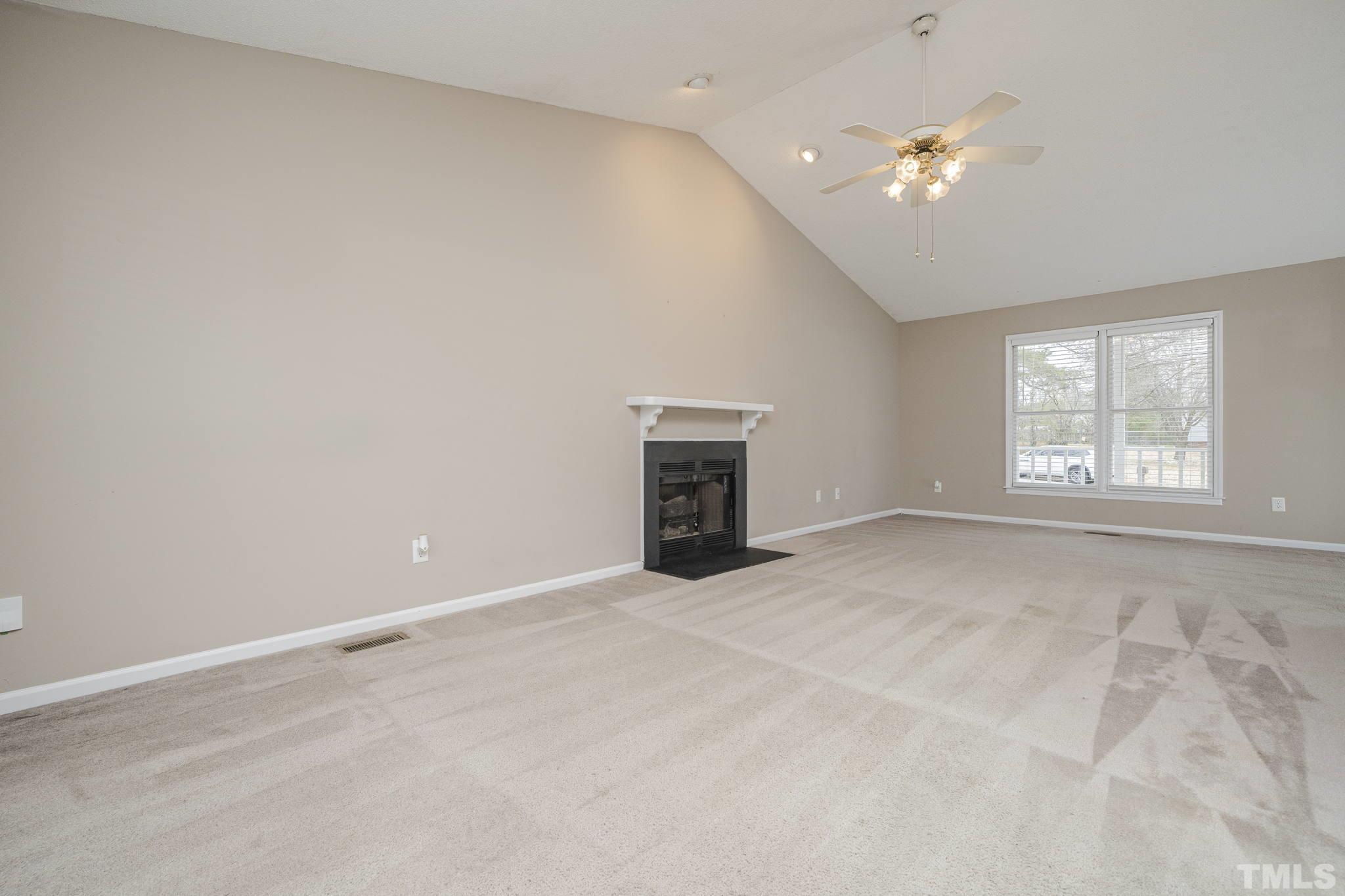 105 Pineview Drive Zebulon, NC 27597 - Photo 10 of 29 an empty room with windows and fireplace