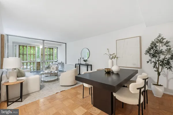 a dining room with furniture and a potted plant