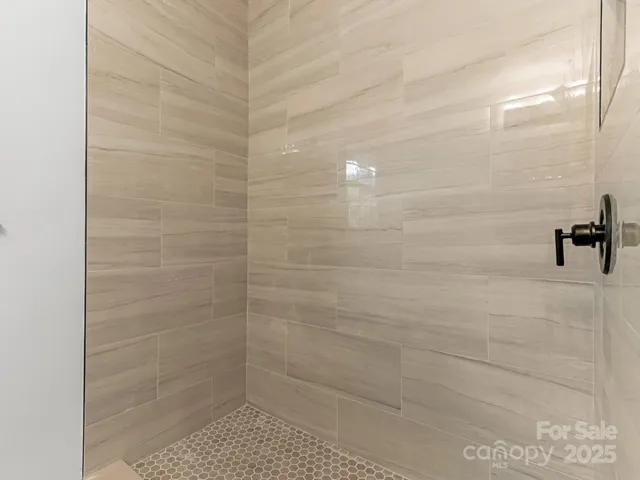 a bedroom with a large bed and wooden floor