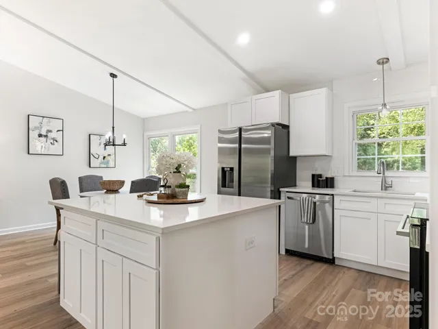 a kitchen with kitchen island white cabinets and stainless steel appliances