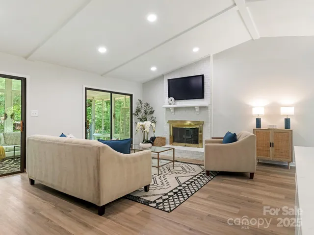 a living room with furniture kitchen view and a chandelier
