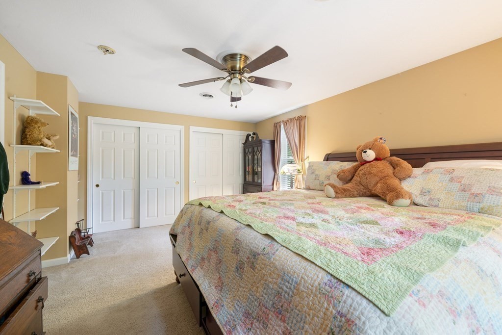 235 Curtis Farm Road Wilton, NH 03086 - Photo 19 of 34 a bedroom with a bed and a chandelier