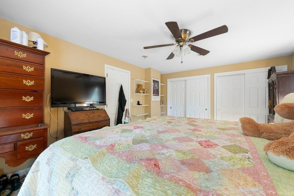 235 Curtis Farm Road Wilton, NH 03086 - Photo 20 of 34 a bedroom with a bed and a flat screen tv
