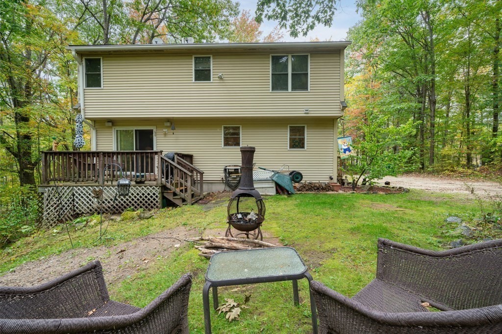 235 Curtis Farm Road Wilton, NH 03086 - Photo 24 of 34 a view of a chair and table in back yard of the house