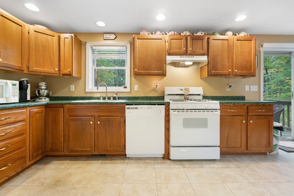 235 Curtis Farm Road Wilton, NH 03086 - Photo 7 of 34 a kitchen with stainless steel appliances granite countertop a stove a sink and a microwave