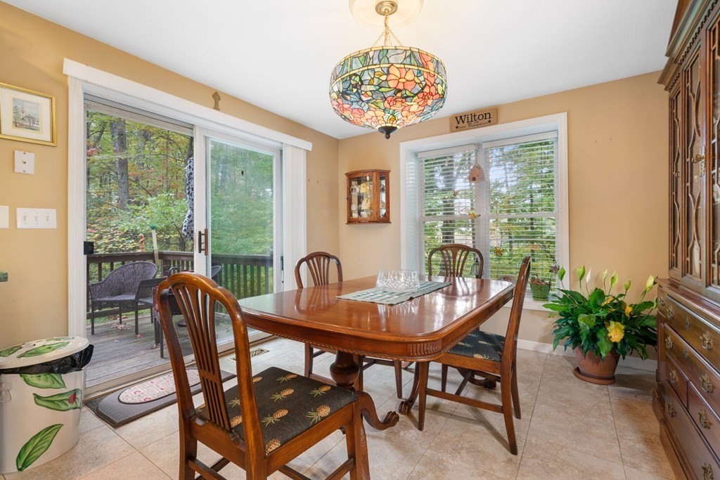 235 Curtis Farm Road Wilton, NH 03086 - Photo 10 of 34 a dining room with furniture potted plants and a large window