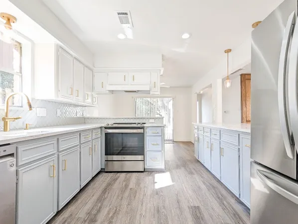 a kitchen with white cabinets and white appliances