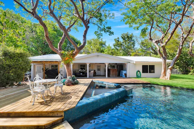 a view of a backyard with table and chairs and a large tree