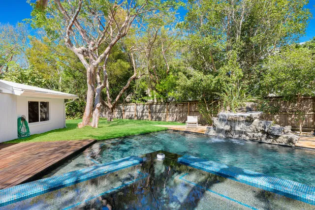 a backyard of a house with lots of green space and wooden benches