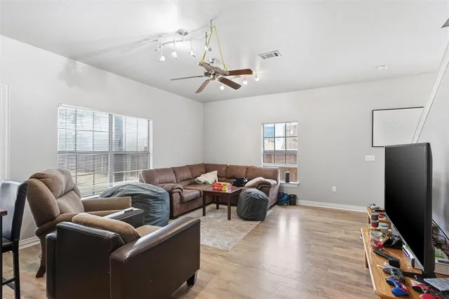 a living room with furniture a ceiling fan and a flat screen tv