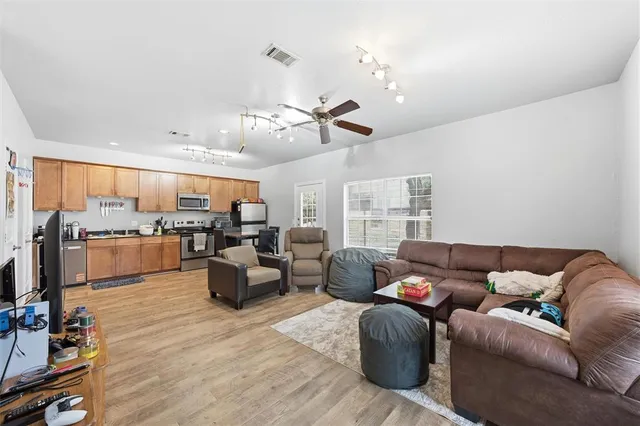 a living room with furniture kitchen view and a chandelier