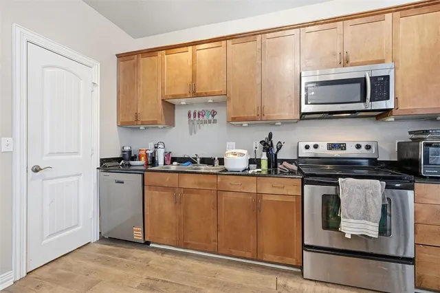 a kitchen with stainless steel appliances granite countertop a stove a sink and a microwave