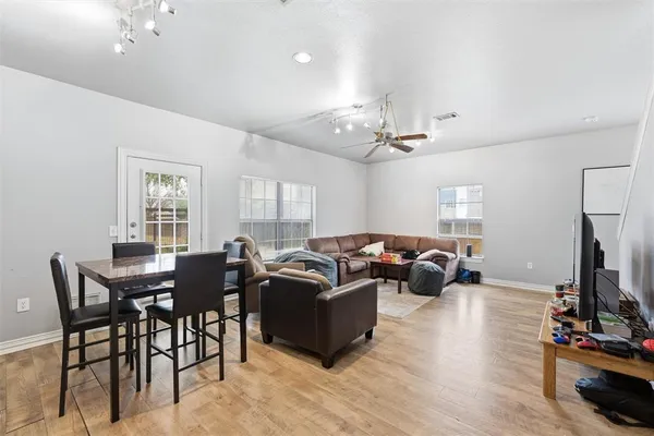 a living room with furniture a chandelier and a flat screen tv