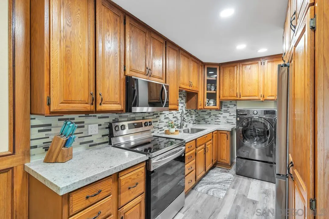 8683 Wahl Street Santee, CA 92071 - Photo 10 of 24 a kitchen with stainless steel appliances granite countertop wooden cabinets a sink and a stove