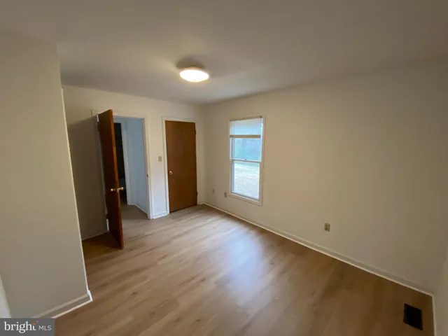 an empty room with wooden floor and closet
