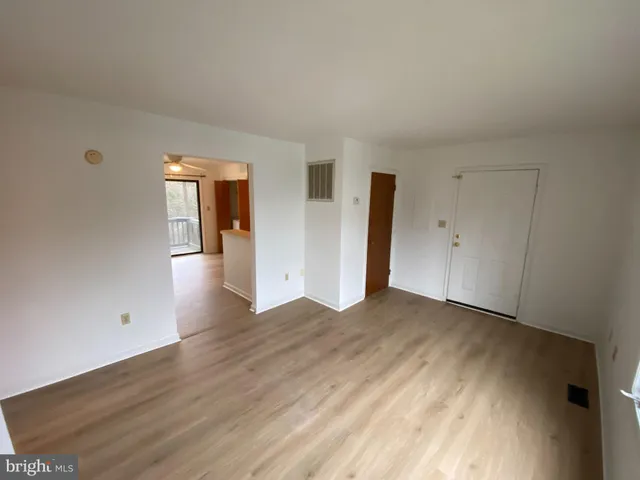 an empty room with wooden floor and mirror