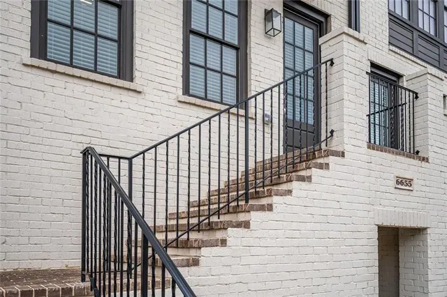 a view of a livingroom with wooden floor a ceiling fan and a kitchen