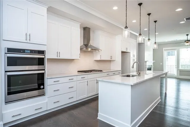 a kitchen with stainless steel appliances granite countertop a stove a sink and a refrigerator