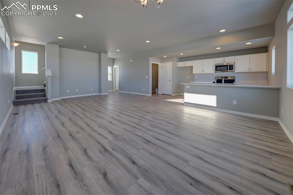 2951 Magic Carpet Loop Colorado Springs, CO 80916 - Photo 6 of 13 a view of an empty room and kitchen with wooden floor