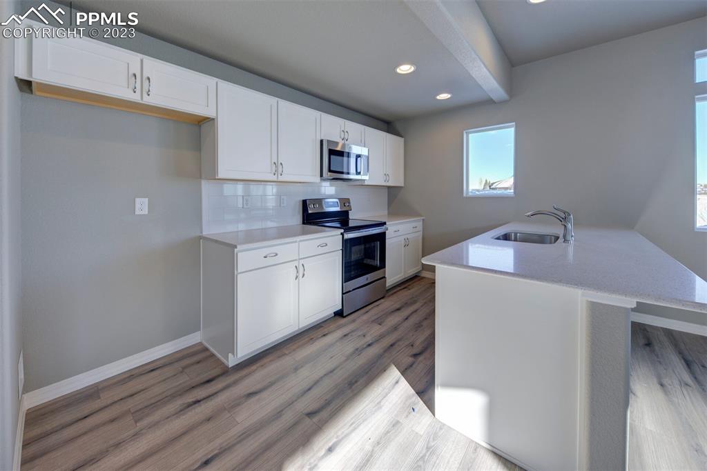 2951 Magic Carpet Loop Colorado Springs, CO 80916 - Photo 7 of 13 a kitchen with a sink stove and cabinets
