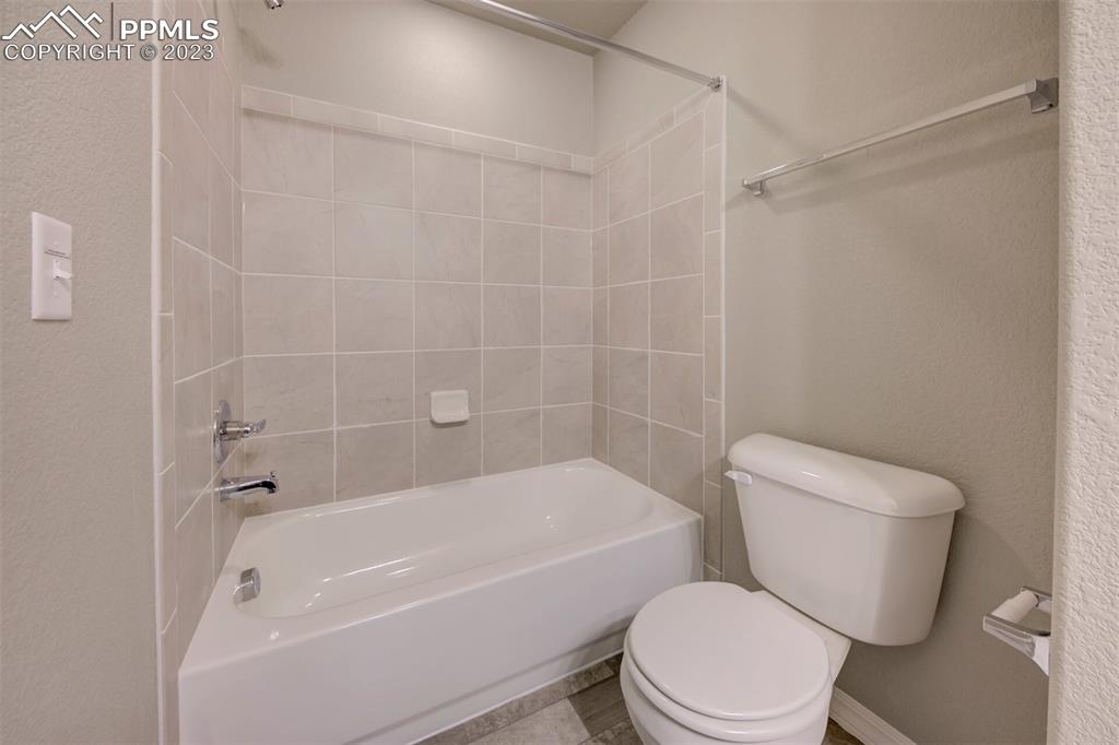 2951 Magic Carpet Loop Colorado Springs, CO 80916 - Photo 10 of 13 a white toilet and tub sitting next to a bathroom sink
