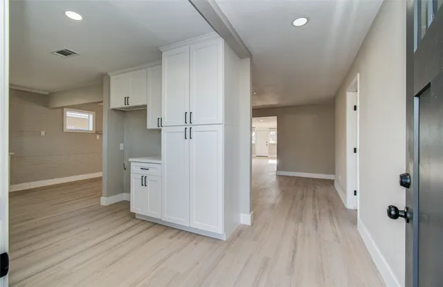 wooden floor in an empty room with a kitchen