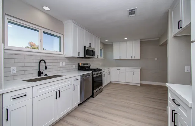 a kitchen with a sink cabinets and wooden floor
