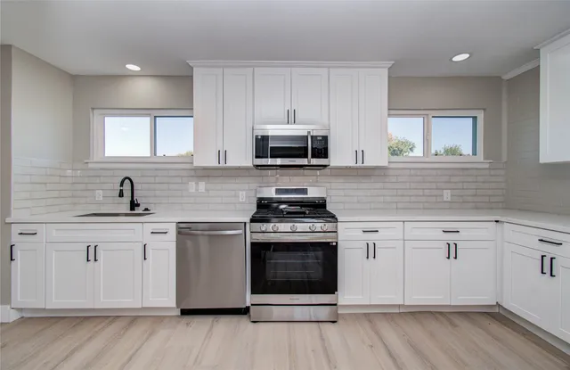 a kitchen with granite countertop wooden floors and stainless steel appliances