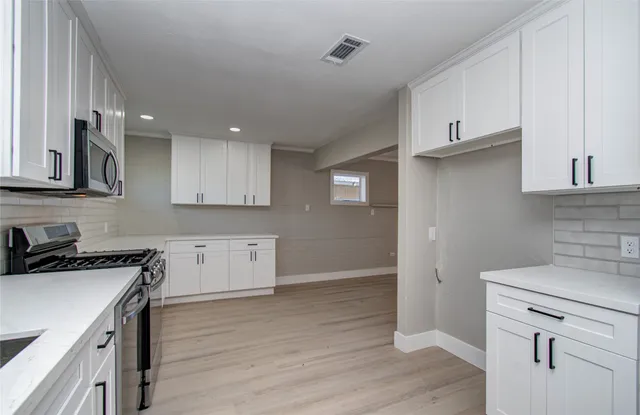 a kitchen with granite countertop a sink cabinets and stainless steel appliances