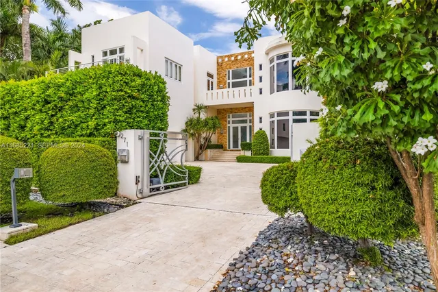 a view of multiple houses with yard and green space