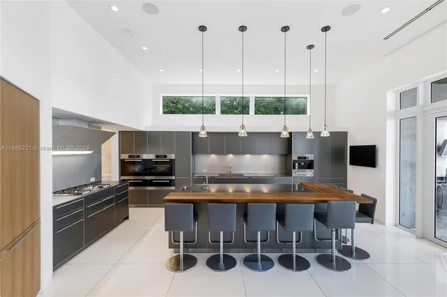 a kitchen with stainless steel appliances kitchen island granite countertop a stove a sink and a refrigerator