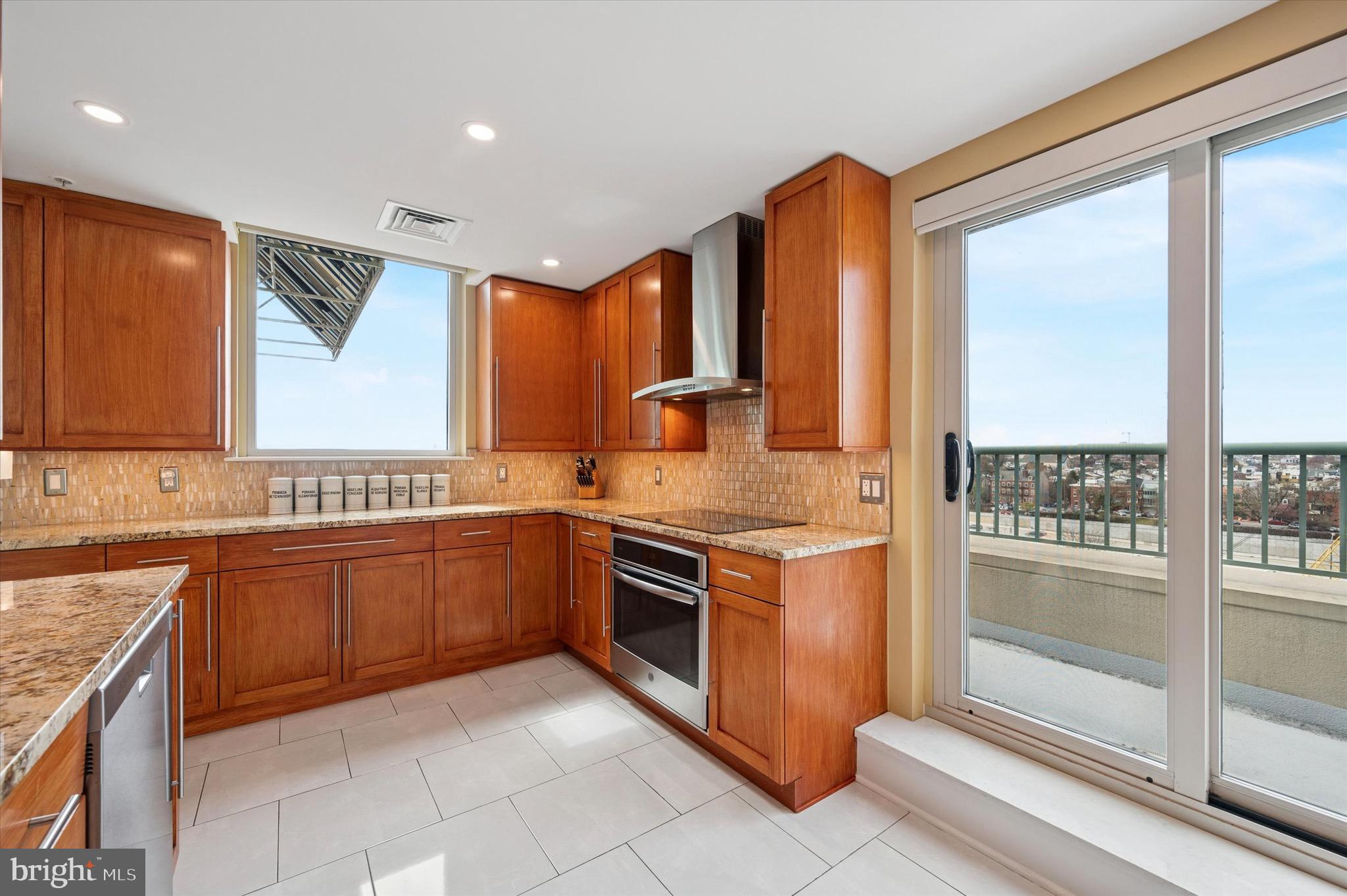 717 South Christopher Columbus Boulevard, Unit 802 Philadelphia, PA 19147 - Photo 11 of 32 a kitchen with stainless steel appliances granite countertop a stove a sink and a microwave