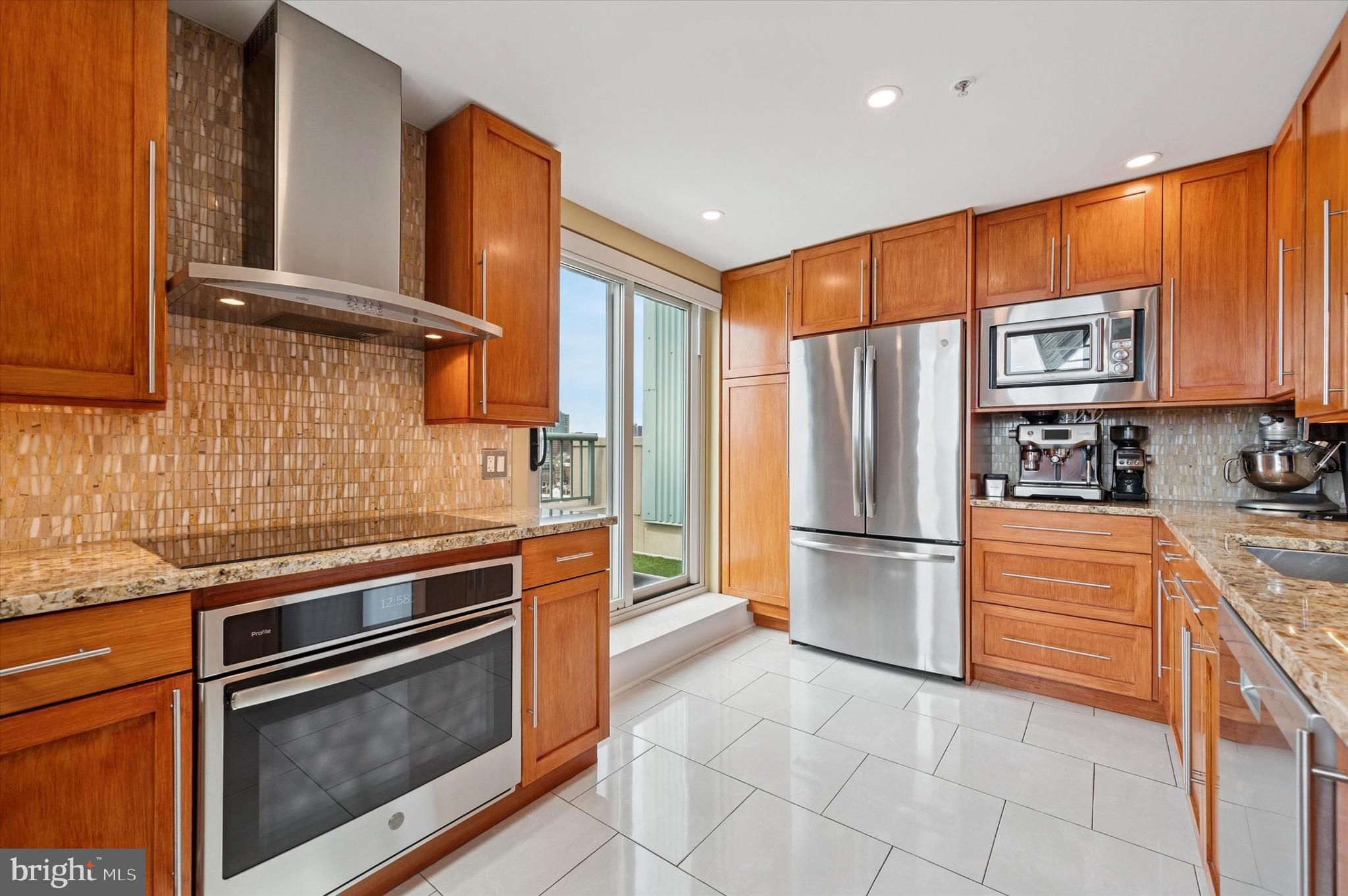 717 South Christopher Columbus Boulevard, Unit 802 Philadelphia, PA 19147 - Photo 12 of 32 a kitchen with granite countertop stainless steel appliances and wooden cabinets
